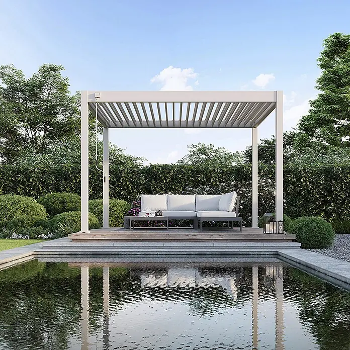 Weide Pergola Classic 3 x 3,6 M Ivory Sand - B x T: 360 x 300 cm, Farbe Gestell: Sand, Aluminium - Moderne hellgraue Lamellenpergola über einer Outdoor-Lounge neben einem Teich.