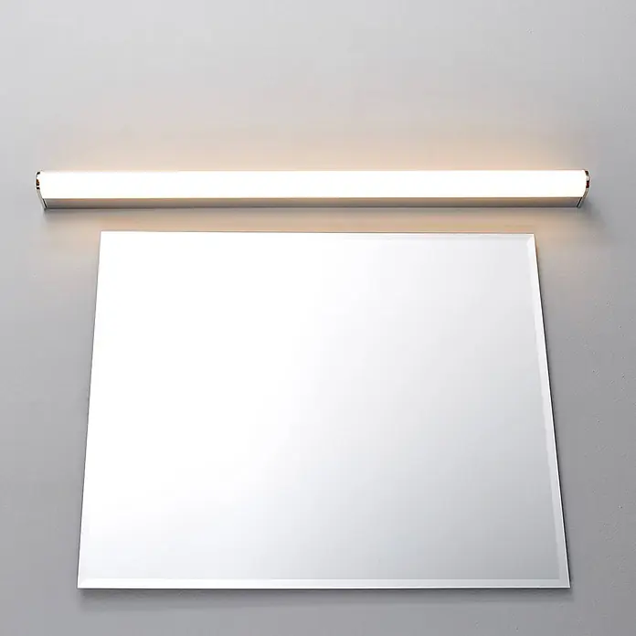 Lindby Wandleuchte Philippa - chrom / silber - Rechteckiger Spiegel mit Facettenschliff, beleuchtet von einer linearen LED-Spiegelleuchte in Chromoptik.