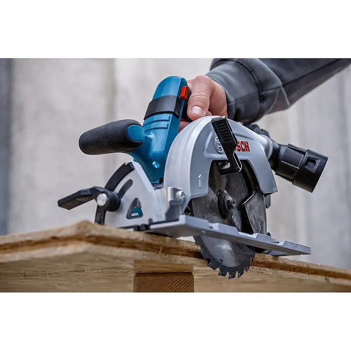 Bosch Professional AMPShare 18V Akku-Handkreissäge GKS 18V-57-2 L - 18 V, Ohne Akku, Durchmesser Sägeblatt: 165 mm, 5.000 U/min - Blaue und graue Bosch Handkreissäge, von einer Hand gehalten, zum Sägen eines Holzbretts positioniert.