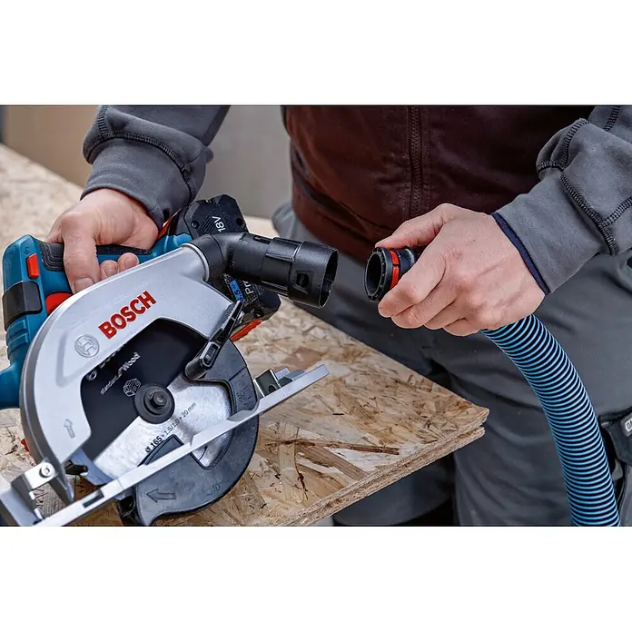 Bosch Professional AMPShare 18V Akku-Handkreissäge GKS 18V-57-2 L - 18 V, Ohne Akku, Durchmesser Sägeblatt: 165 mm, 5.000 U/min - Blaue/silberne Bosch Akku-Kreissäge wird an einen blau/schwarzen Absaugschlauch angeschlossen.