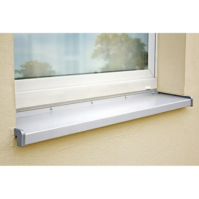 Sarei Fensterbank nach Maß - L x B: 300 x 7 cm, Aluminium, Weißaluminium/Silber - Nahaufnahme einer Fensterbank aus Aluminium, die an einer hellgelben Hauswand montiert ist und das Licht reflektiert.