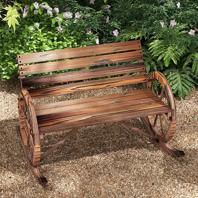 Furnicato Gartenbank karbonisiertes Tannenholz - B x T x H: 88 x 105 x 74 cm, Tannenholz, Verkohlt - Garten-Schaukelbank aus dunklem Holz mit Wagenrad-Armlehnen auf Kies im Grünen.