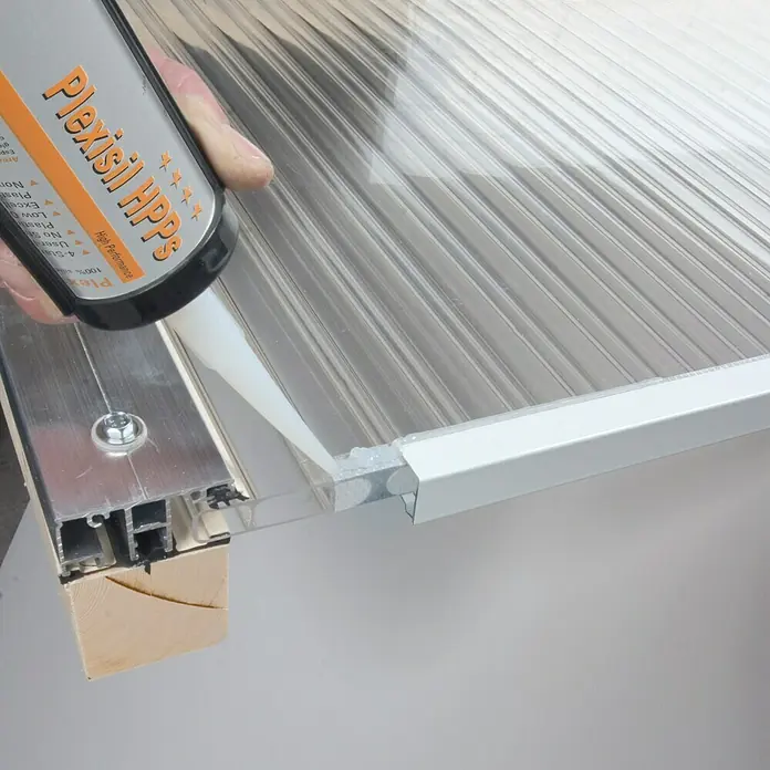 Kartuschenkleber Plexisil - Transparent, 310 ml - Anwendung von Plexisil HPPS Hochleistungsdichtstoff auf einer transparenten Platte für eine sichere und dauerhafte Abdichtung.
