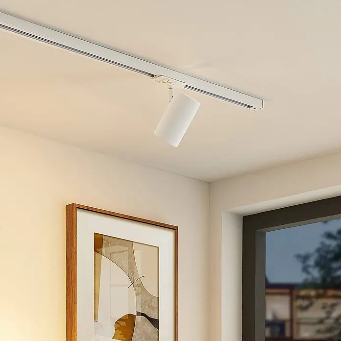 Lindby LED-Spannseilsystem Linaro - L x B x H: 11,7 x 6 x 12,5 cm, weiß / opal, weiß / opal - Weißer zylindrischer Deckenspot an einer Stromschiene, der einen Raum beleuchtet.