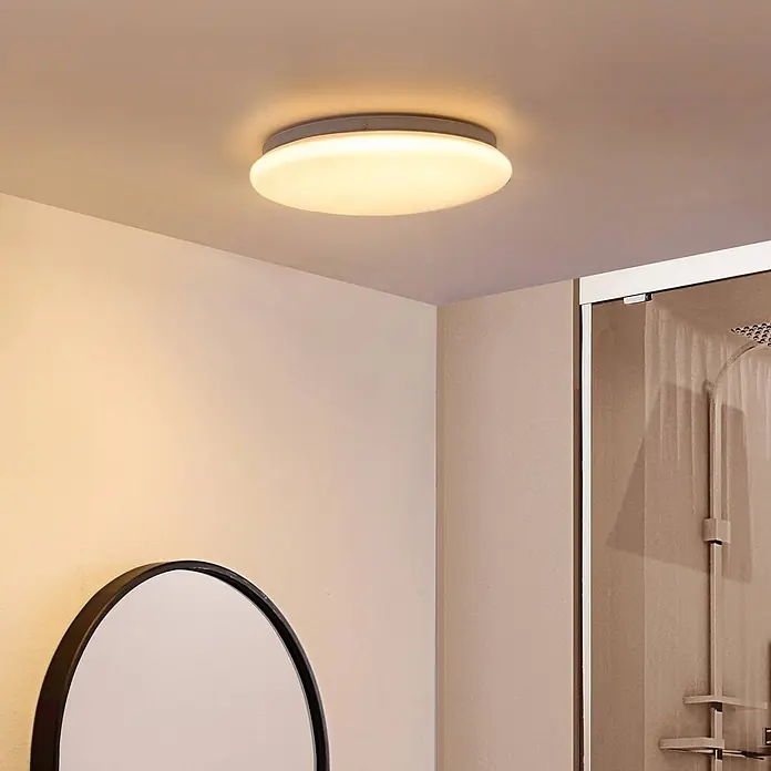 Lindby Deckenleuchte Emeryn - weiß / opal - Flache runde LED-Deckenleuchte mit weißem Diffusor und grauem Rahmen, beleuchtet einen modernen Raum.