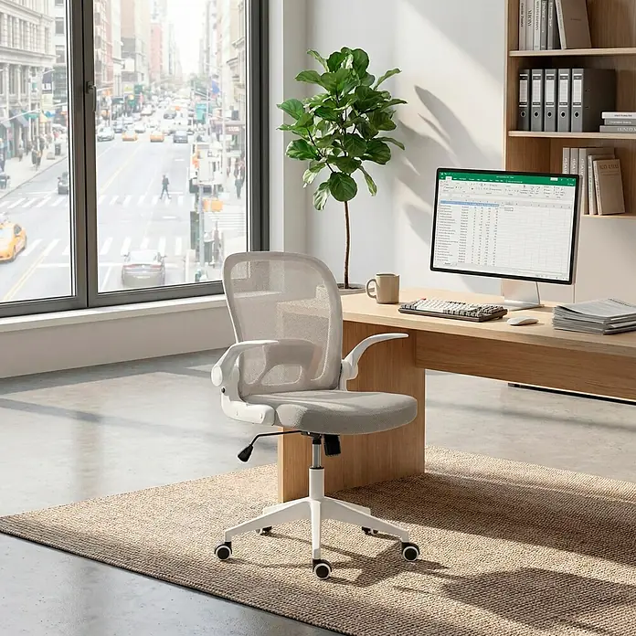Silla de oficina Vega - Gris/Blanco, Reposabrazos - Silla de oficina gris claro de malla y tela con estructura blanca, situada frente a un moderno escritorio de madera en una oficina luminosa.