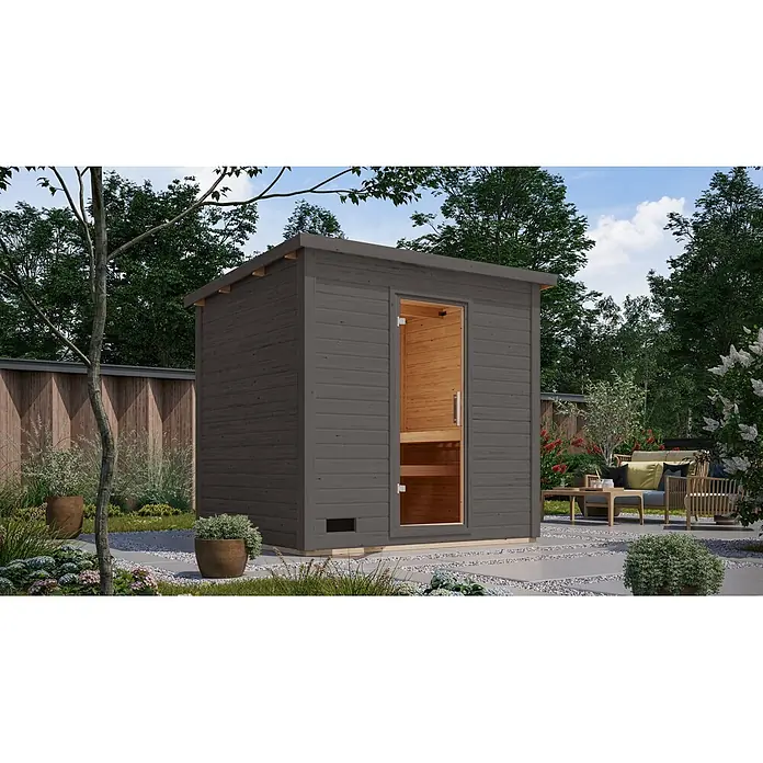 Karibu Saunahaus Kaapi 4 - Ohne Ofen, Anthrazit, L x B x H: 196 x 231 x 238 cm - Dunkelgraue Outdoor-Saunakabine aus Holz mit Schrägdach und Glastür, in einem Garten.