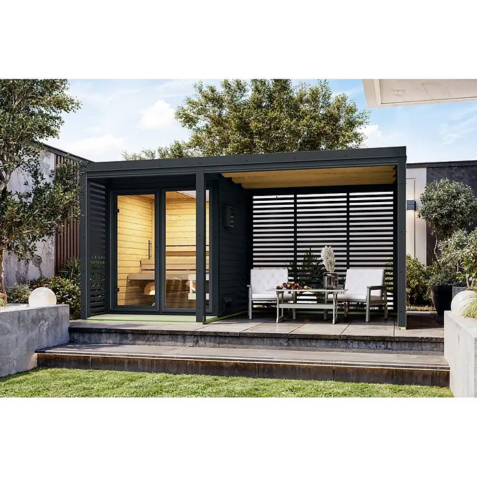 Karibu Saunahaus Heimdall - 9 KW Ofen mit interner Steuerung, Anthrazit, L x B x H: 276 x 452 x 231,5 cm - Dunkelgraue Außensauna und Pergola mit Naturholz-Interieur und Lounge-Bereich mit weißen Stühlen auf einer Terrasse.