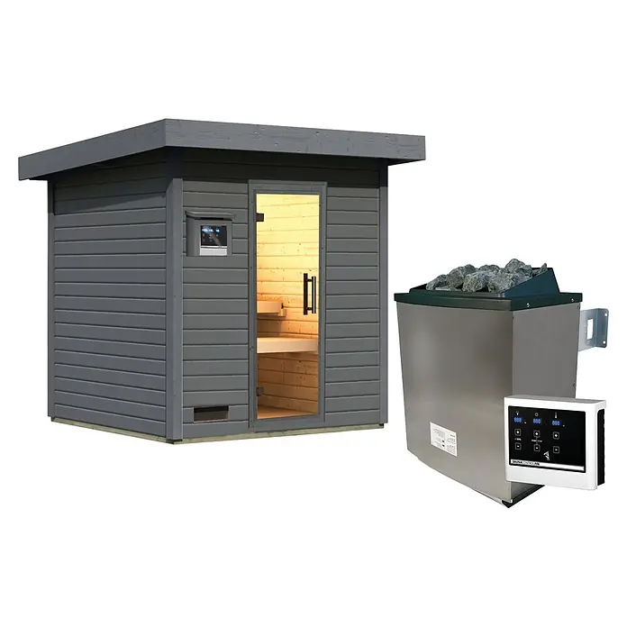 Karibu Saunahaus Kaapi 3 - 9 KW Ofen mit externer Steuerung, Anthrazit, L x B x H: 196 x 196 x 228 cm - Graue Holzsaunakabine mit Glastür, daneben ein Edelstahl-Saunaofen mit Steinen und digitalem Bedienfeld.