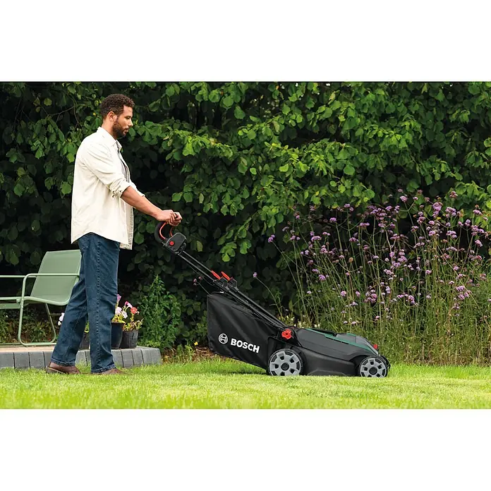 Bosch Power for All 18V Akku-Rasenmäher ROTAK18V2-43 - Ohne Akku, Schnittbreite: 43 cm - Ein Mann bedient einen schwarz-grünen Bosch Rasenmäher.