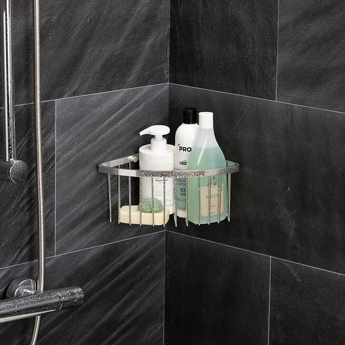 Tatay Aluminium Cesta de baño angular + QuickFix - 20 x 11,5 x 20 cm, Cromo - Cesta de ducha de esquina de metal plateado con artículos de tocador y jabón, montada en una ducha con azulejos oscuros.