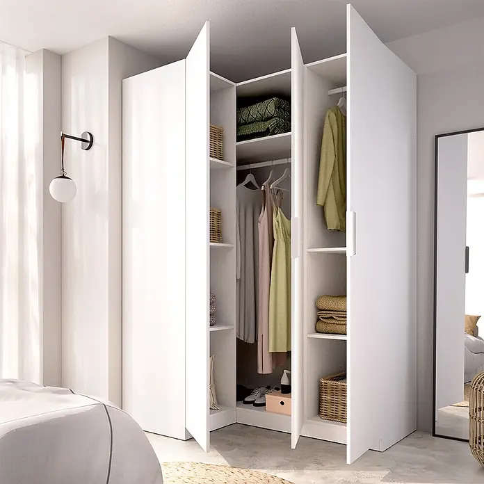 Dekit Armario para ropa Emax - L x An x Al: 95 x 142,2 x 203,5 cm, Blanco, Rinconero - Armario esquinero blanco, abierto y mostrando estantes, ropa colgada y cestas de almacenamiento, integrado en un dormitorio moderno.