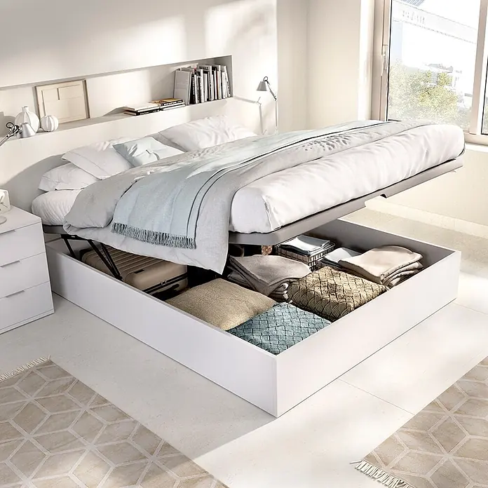 Dekit Canapé Nest - L x An x Al: 190 x 150 x 32 cm, Blanco - Cama blanca con almacenamiento elevable, revelando un amplio espacio bajo el colchón lleno de textiles y equipaje para una organización práctica.