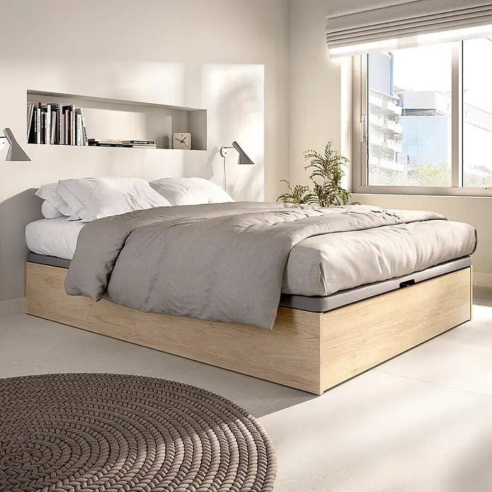 Dekit Canapé Lan - L x An x Al: 190 x 135 x 32 cm, Natural, Zapatero - Cama moderna con estructura de almacenaje de madera clara, colchón gris y ropa de cama blanca y gris en un dormitorio luminoso.