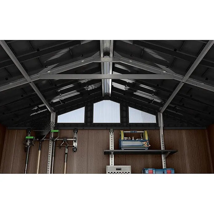 Keter Caseta de jardín Stronghold 8x8 - Medidas ext. (An x Pr): 244 x 248 cm, Plástico, Marrón/Negro, 6 m² - Interior de un cobertizo de almacenamiento con techo oscuro, vigas claras, paredes marrones, claraboyas, estanterías para herramientas y baldas.