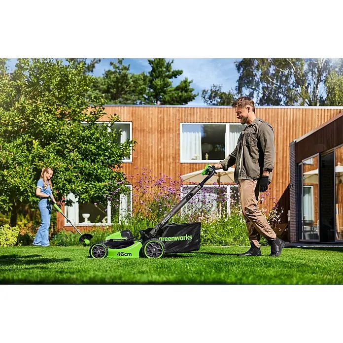 Greenworks Akku-Rasenmäher Gen2 GW 2X24V BL 46 cm - 48 V, 2 Akkus, 4 Ah, Schnittbreite: 33 mm - Ein grüner Greenworks 46cm Akku-Rasenmäher mäht Gras, während ein passender Rasentrimmer zum Kanten trimmen im Garten verwendet wird.