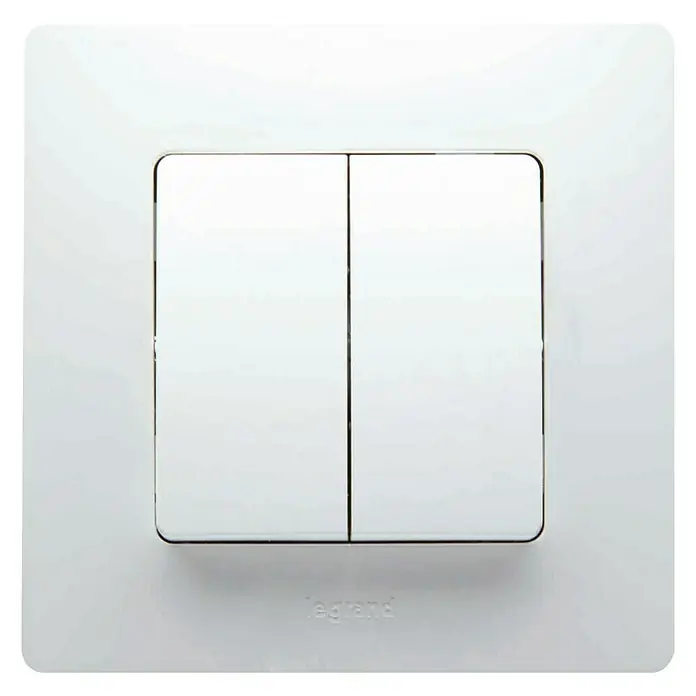 Legrand Niloé Monoblock Conmutador doble - Blanco, Instalar, Plástico - Interruptor de luz doble Legrand con dos interruptores blancos y detalles plateados sobre una placa blanca para un control de iluminación moderno.