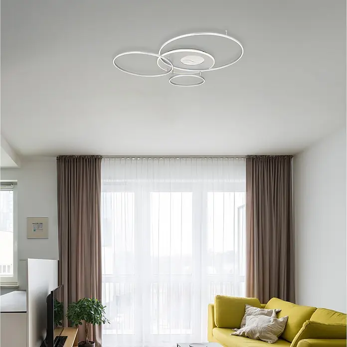 Globo LED-Deckenleuchte Invertina - 54 W, L x B x H: 900 x 700 x 130 mm, Warmweiß - Moderne weiße und silberne LED-Deckenleuchte mit ineinandergreifenden Ringen, in einem Wohnzimmer installiert.