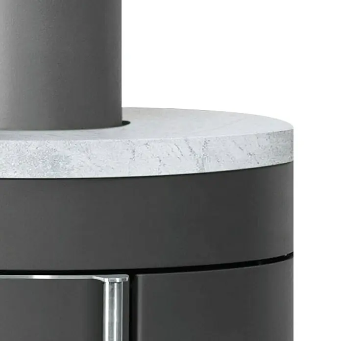 Justus Kaminofen Mino 2.0 - 5,5 kW, Raumheizvermögen: 88 m³, Farbe Verkleidung: Speckstein, Schwarz - Detailaufnahme eines modernen Kaminofens mit runder Form, grauem Korpus und einer Abdeckung aus grauem Marmor.