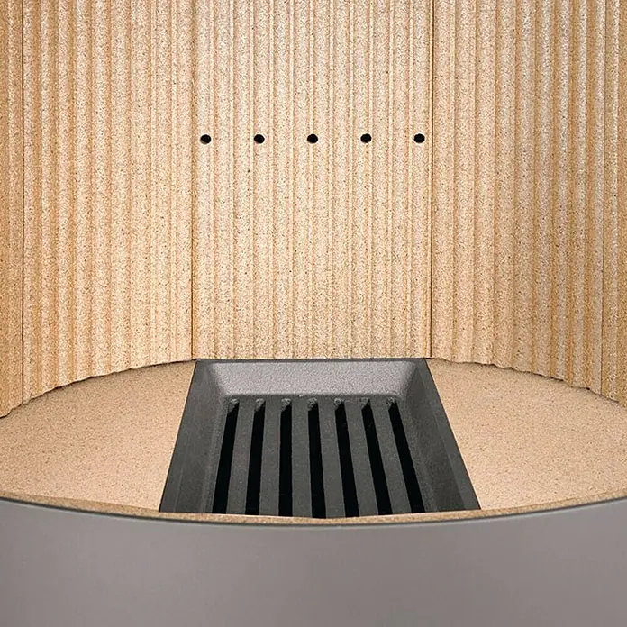Justus Kaminofen Mino 2.0 - 5,5 kW, Raumheizvermögen: 88 m³, Farbe Verkleidung: Sandstein, Schwarz - Nahaufnahme eines Kaminofens mit Rillenmuster an der Rückwand und einem gusseisernen Rost.