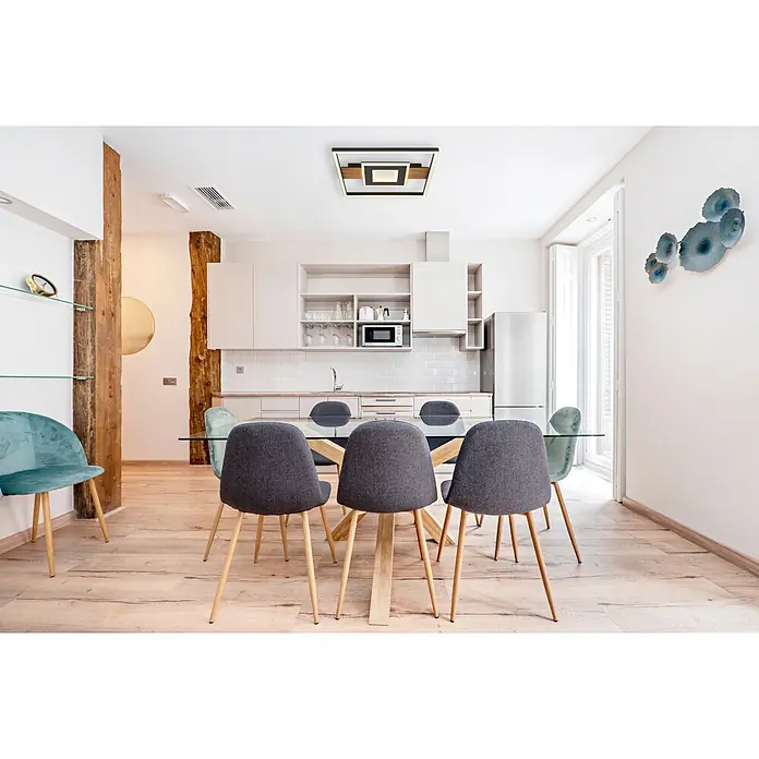 Globo LED-Deckenleuchte Pikara - L x B x H: 37,8 x 37,8 x 5 cm, Braun, 24 W, Lichtfarbe: Warmweiß, 800 lm - Ein moderner Essbereich mit Glastisch, Holzgestell und grauen Stoff- sowie tealfarbenen Samtstühlen in einer modernen Küche.