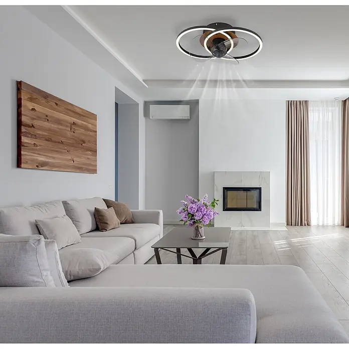 Globo Ventilador de techo Karen - 28 mm - Ventilador de techo moderno con anillos negros, detalles de madera, luz LED y aspas transparentes, circulando aire en una sala de estar luminosa.