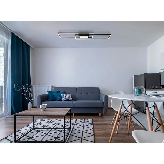 Globo LED-Deckenleuchte Saunders - 42 W, L x B x H: 960 x 196 x 50 mm - Modernes Wohn- und Esszimmer mit grauem Sofa, Holztisch, weißer Essgruppe und petrolfarbenen Vorhängen.