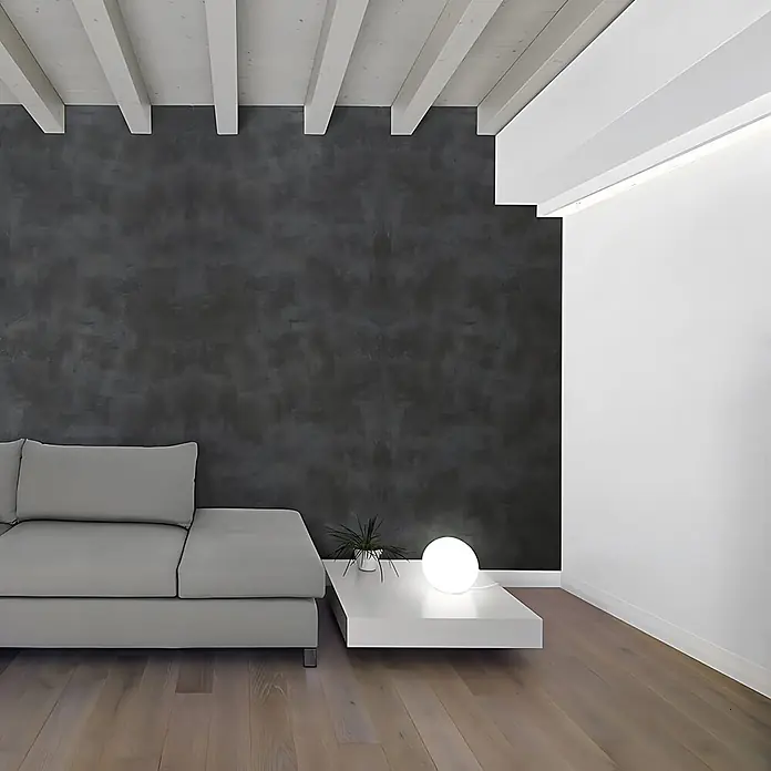 Wallface Wandpaneel 19798-NA Antigrav CEMENT Dark Wandpaneel Beton Optik anthrazit 2,6 m2 - 2.600 x 1.000 mm - Helles graues Sofa und weißer niedriger Couchtisch in einem modernen Wohnzimmer mit dunkler Akzentwand.