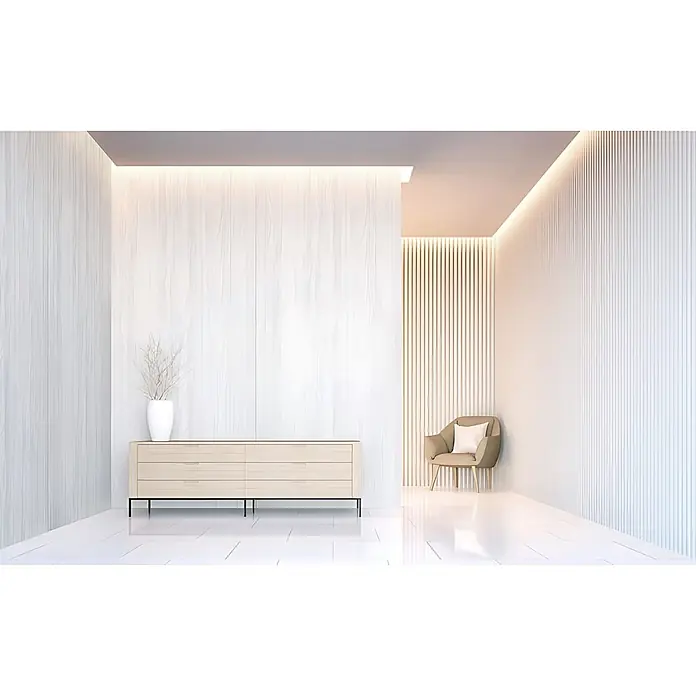 Wallface Wandpaneel 24950 DAKOTA Snow White Wandverkleidung mit Natur Dekor matt weiß 2,6 m2 - 2.600 x 1.000 mm - Hellholz-Kommode mit Trockenpflanze in Vase, dazu ein weicher brauner Sessel mit Kissen in einem modern beleuchteten Raum.