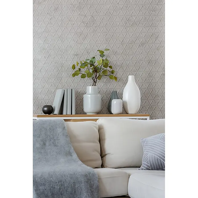 Wallface Wandpaneel 22740 CUBE VELVET Pearl Wandverkleidung in Leder Optik matt grau 2,63 m2 - 2.613 x 1.005 mm - Strukturierte hellgraue Wandfliesen mit einem wiederholten 3D-Geometriemuster aus ineinandergreifenden Dreiecken als dekorativer Akzent in einem modernen Wohnraum.