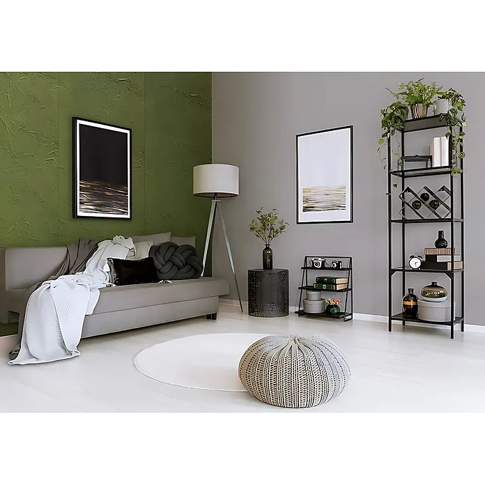 Wallface Wandpaneel 22735 CREPA VELVET Avocado Wandverkleidung in Leder Optik matt grün 2,63 m2 - 2.613 x 1.005 mm - Ein runder, hell gewebter Pouf auf einem weißen Teppich, der gemütliche Sitzgelegenheit oder Fußhocker in einem modernen Wohnzimmer bietet.