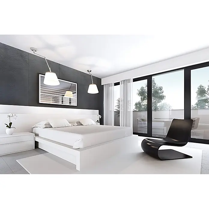 Wallface Wandpaneel 22718 LAVA VELVET Volcano Wandverkleidung in Stein Optik matt grau 2,60 m2 - 2.600 x 1.000 mm - Modernes Schlafzimmer mit weißem Bett, weißem Nachttisch und schwarzem Lounge-Sessel.