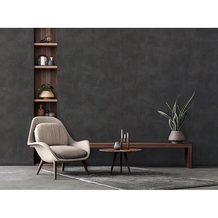 Wallface Wandpaneel 25515 CEMENT Dark Nature Wandpaneel Beton Optik matt anthrazit 2,6 m2 - grau, 2.600 x 1.000 mm - Ein modernes Wohnzimmer mit einem hellbeigen Polstersessel, einem runden Couchtisch aus dunklem Holz und einer langen dunklen Holzbank vor einer dunkelgrauen Wand.