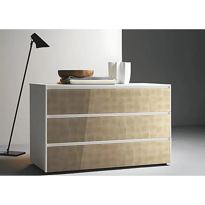 Wallface Wandpaneel 17841 LUXURY Wandpaneel Glas-Optik Cubes-Muster bronze grau 2,60 qm - 2.600 x 1.000 mm - Weiße Kommode mit drei hellgoldenen, strukturierten Schubladen. Eine Holzschale, Textilien und weiße Vasen stehen darauf.