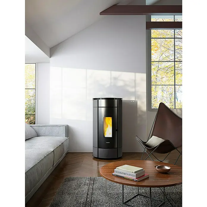 FreePoint Pelletofen Globe - 10,5 kW, Raumheizvermögen: 252 m³, 0,6 kg/h - 2,5 kg/h, Anthrazit - Das Bild zeigt einen modernen Pelletofen von FreePoint in einem stilvollen Wohnzimmer. Der Ofen ist schwarz und hat ein kleines Sichtfenster für das Feuer.