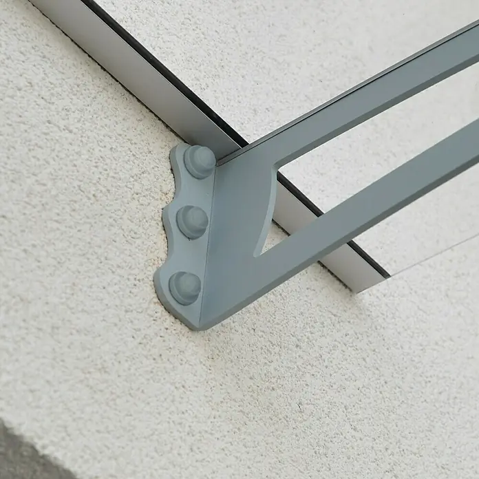 Palram – Canopia Marquesina para puerta Aquila - 302 x 91,5 x 17,5 cm, Gris antracita, Color del techo: Claro - Primer plano de un toldo gris con soporte en una pared blanca. La estructura parece robusta y moderna.