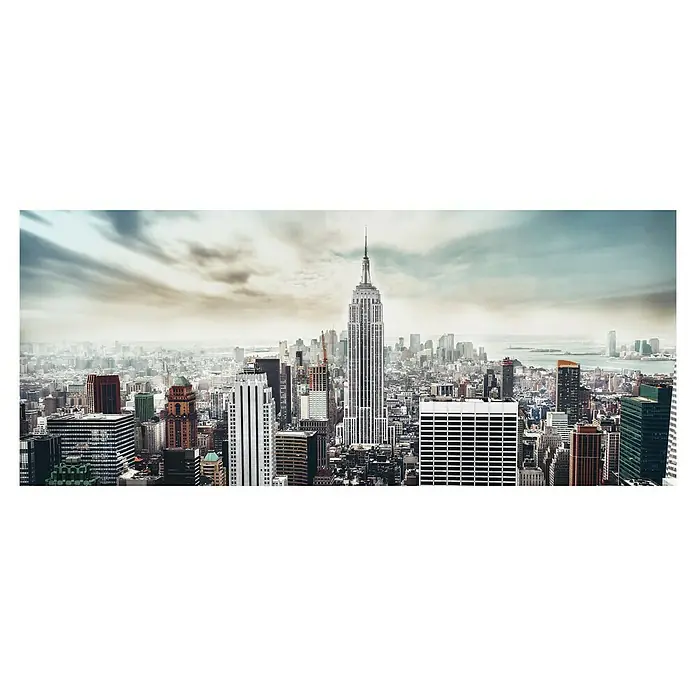 Glasbild - Manhattan, B x H: 125 x 50 cm - Panoramaaufnahme der Skyline von New York City mit dem ikonischen Empire State Building im Zentrum, eingefangen unter einem dramatischen Himmel.