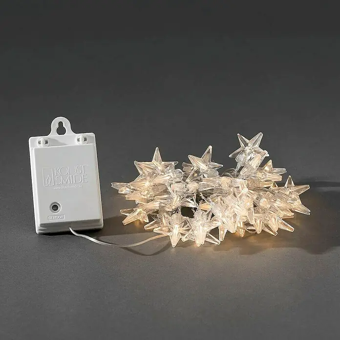 Konstsmide LED-Lichterkette Sterne - Außen, Lichtfarbe: Warmweiß, Anzahl Leuchtmittel: 40 Stk., Batteriebetrieben - Nahaufnahme von einer transparenten Konstsmide-Lichterkette mit Sternen und einem Sensor für stimmungsvolle Beleuchtung.