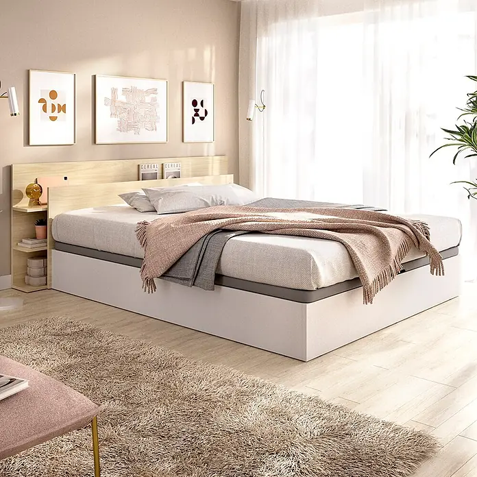 Dekit Cabecero de cama Tori - L x An: 209,2 x 181,2 cm, Roble claro, Con canapé - Cama moderna con base blanca y cabecero de madera clara con estante integrado, vestida con mantas grises y rosas en un dormitorio.