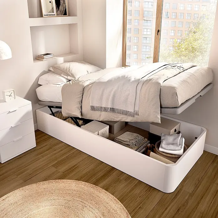 Dekit Canapé Round - 190 x 90 x 32 cm, Blanco, Abatible - Cama canapé blanca con colchón levantado que revela un amplio espacio de almacenamiento bajo la cama.