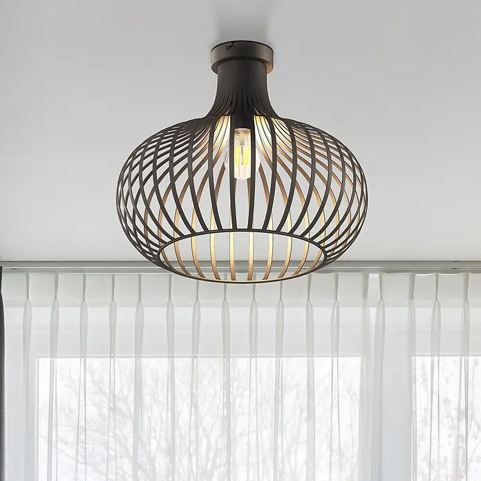 Globo Deckenleuchte Mateo - 40 W, E27 - Schwarze Gitterdeckenlampe mit sichtbarer Glühbirne, beleuchtet einen Raum mit transparenten Vorhängen.