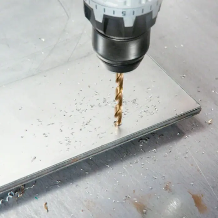 Bosch Broca para metal HSS-CO - Diámetro de la broca: 3 mm, Longitud de trabajo: 33 mm - Primer plano de un taladro perforando un agujero en una pieza de metal, con virutas de metal esparcidas alrededor.