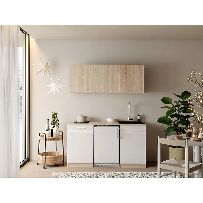Respekta Miniküche Ingrid - Breite: 150 cm, Weiß, Mit Kochfeld + Kühlschrank - Kompakte Küchenzeile mit hellen Holz-Oberschränken und weißen Unterschränken mit Spüle und Kochfeld, in einem hellen Raum.