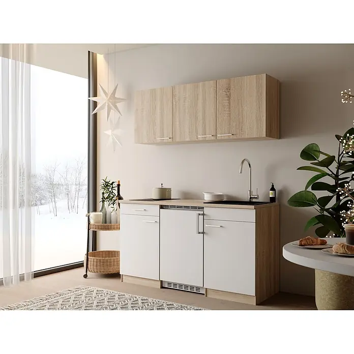 Respekta Miniküche Ingrid - Breite: 150 cm, Weiß, Mit Kochfeld + Kühlschrank - Kompakte Küchenzeile aus heller Holzoptik und weißen Schränken, mit Spüle und Kochfeld, in einem hellen Raum mit Fenster.