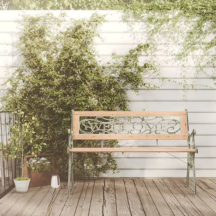 Furnicato Gartenbank Tannen-Massivholz - B x T x H: 122 x 51 x 73 cm, Braun - Eine hölzerne Gartenbank mit dekorativer Metallrückenlehne und „WELCOME“-Schriftzug, auf einer Holzterrasse inmitten von Grün.