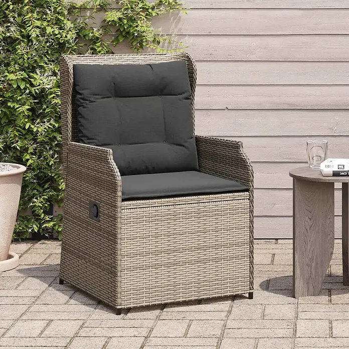 Furnicato Gartenbank - Grau - Geflochtener Outdoor-Sessel in Hellbraun mit dunkelgrauen Kissen auf einer Terrasse.