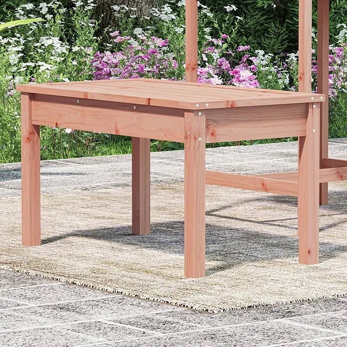 Furnicato Gartenbank - Natürliches Douglasie - Rotbrauner Gartentisch aus Holz mit Lattenplatte auf einer Terrasse mit Teppich, umgeben von Pflanzen.