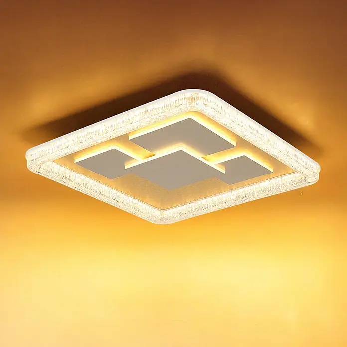 Globo LED-Deckenleuchte Loraine - 40 W, L x B x H: 488 x 488 x 70 mm - Quadratische LED-Deckenleuchte mit strukturierter Kante und geometrischen weißen Paneelen, beleuchtet eine warme gelbe Decke.