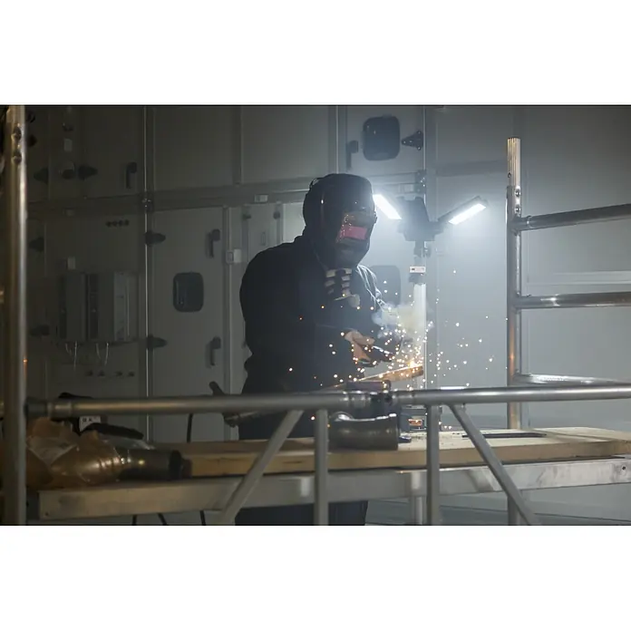 Brennenstuhl Mobiler LED-Strahler Dreikopf Stativstrahler - 100 W, L x B x H: 26 x 21 x 106 cm, IP34 - Schweißer mit schwarzer Schutzausrüstung und Helm arbeitet an Metall und erzeugt helle Funken.
