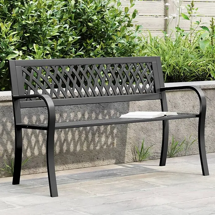 Furnicato Gartenbank - Schwarz - Dunkelgraue Metallgartenbank mit gemusterter Rückenlehne, ein Buch liegt auf der Sitzfläche im Garten.